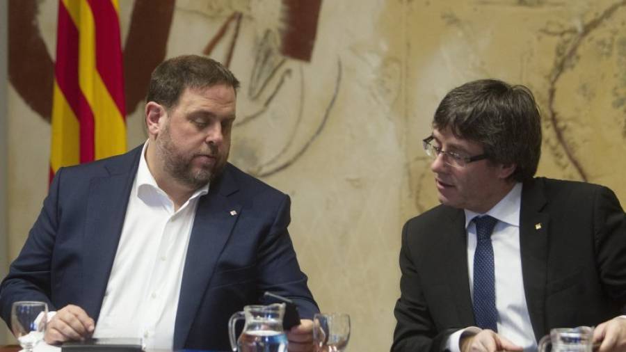 El presidente de la Generalitat, Carles Puigdemont, junto al vicepresidente, Oriol Junqueras, durante la reunión semanal del ejecutivo catalán. EFE/Marta Pérez
