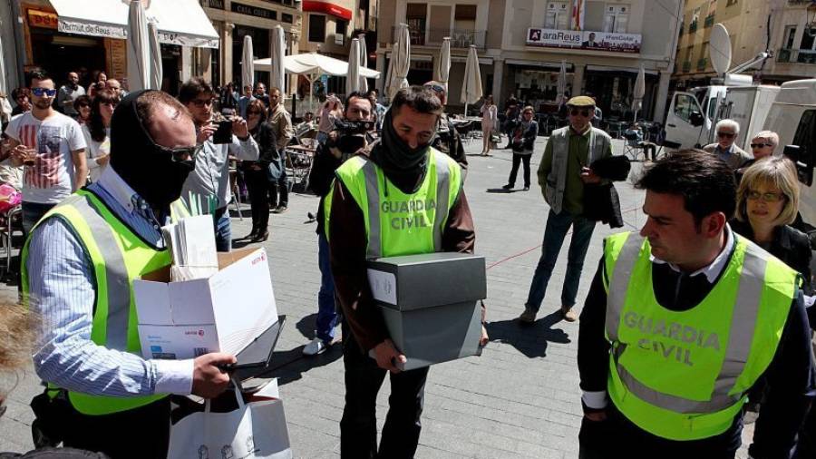Agentes de la Guardia Civil, llevándose documentos del Ayuntamiento de Reus. Foto: Alba Mariné