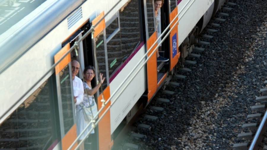 Imatge darxiu de diversos passatgers que treuen el cap per les portes d'un tren per a respirar aire fresc. FOTO: CARME GASENI