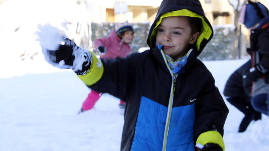 Un nen juga amb la neu al pati de l'escola Guillem de Mont-rodon de Vic, aquest dimarts al mat&iacute;.
