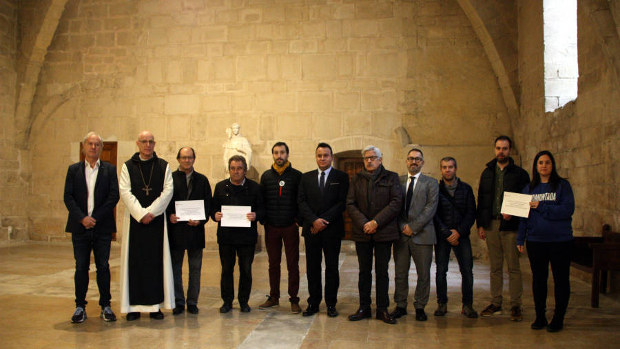 Imatge d’ahir al matí amb els alcaldes de la Conca de Barberà i els membres de Riuada Solidària i el pare abat al monestir de Poblet. FOTO: ACN