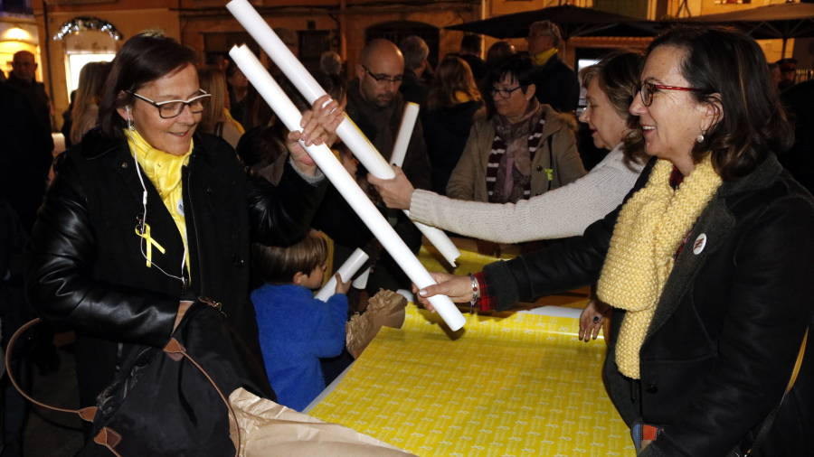Pla mig de volunt&agrave;ries repartint paper d'embolicar regals de color groc abans de la concentraci&oacute; de suport a Oriol Junqueras a la pla&ccedil;a de la Font de Tarragona. FOTO: ACN