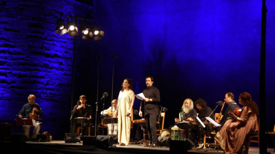 Pla general de dos cantants i dels músics damunt l'escenari, amb el mestre Savall a l'esquerra, durant el concert 'Orient-Occident' del IV Festival de Música Antiga de Poblet. Foto: ACN