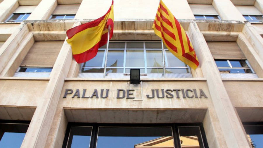 Pla contrapicat de la façana d'entrada a l'Audiència de Tarragona, amb el rètol de 'Palau de Justícia' i les banderes espanyola i catalana. Imatge del 30 de maig del 2016.