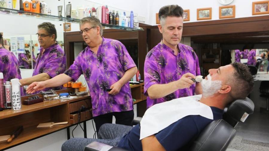 Javi Torrente, en primer término, en la barbería Casado-Torrente ubicada en la calle Hospital. Foto: Alba Mariné