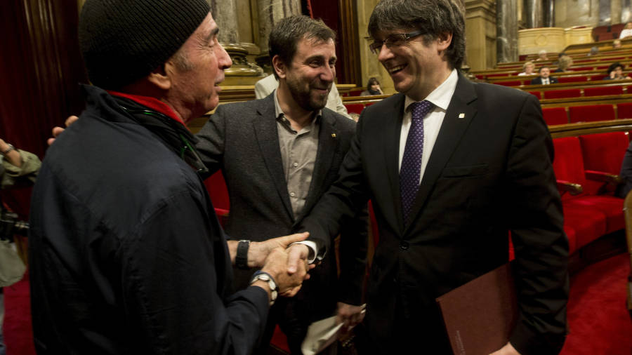 El president va saludar ahir efusivament el diputat Lluís Llach. Darrere, el conseller Antoni Comín. GARCÍA/EFE