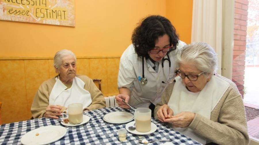 Neus Martínez, médico de familia, ayudando a algunas residentes en la toma de su medicación. Foto: Alba Mariné