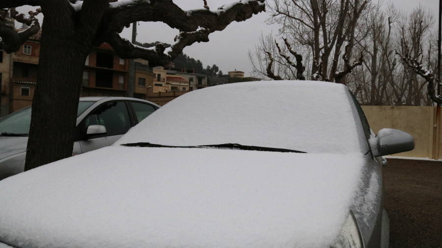 Pla obert d'un cotxe completament cobert de neu aparcat al municipi de Riudecols (Baix Camp)