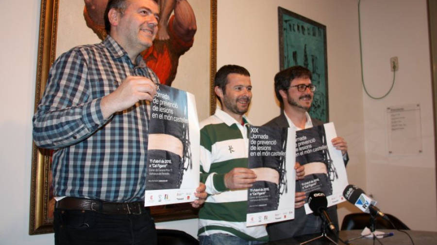 Josep Cabré, president dels Castellers de Vilafranca, Pere Almirall, cap de colla, i Andreu Botella, membre de la CCCC, ensenyen el cartell de la 19a Jornada de prevenció de lesions. Foto: ACN