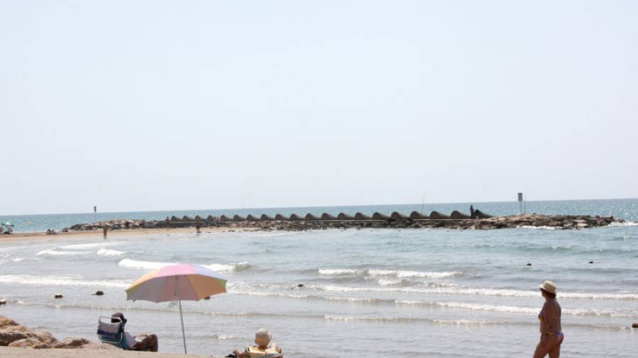 Gran pla general d'una platja de Cunit, amb banyistes passejant i prenent el sol, mentre el dron (a la part superior dreta de la imatge) sobrevola la zona. Foto: ACN