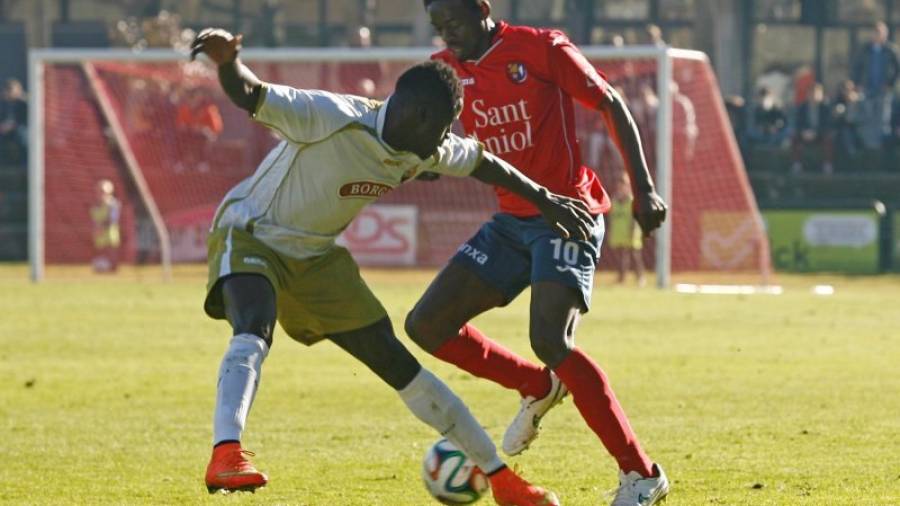 El defensa rojinegro Cassama, tratando de detener el avance del jugador local Musa. Foto: Diari de Girona