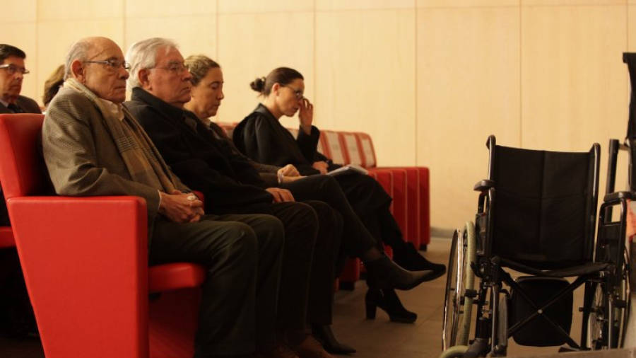 Fèlix Millet, Jordi Montull i Gemma Montull, al banc dels acusats, amb la cadira de rodes de Millet davant. Imatge de l'1 de març del 2017.