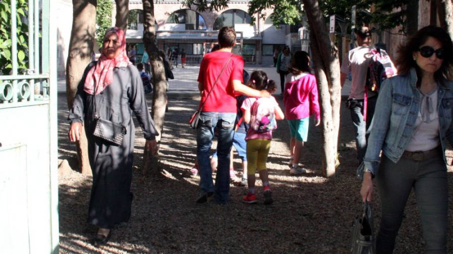 Pares portant els seus fills a l'escola Maria Cortina de Reus aquest dilluns a les nou del matí. Foto: ACN