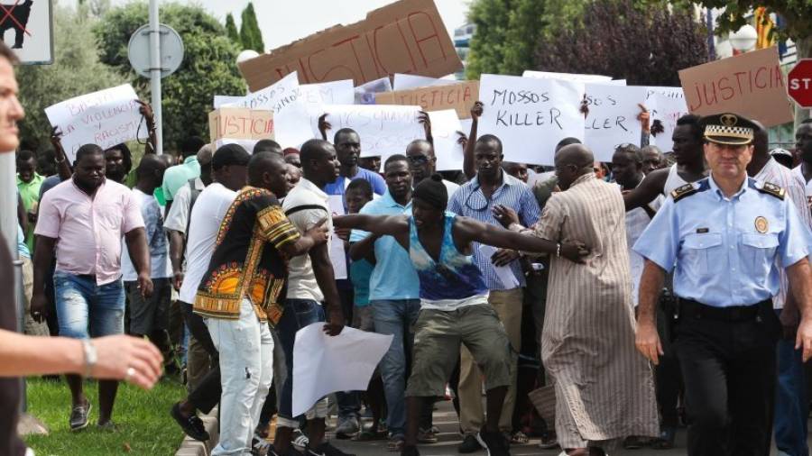 Membres del col·lectiu senegalès durant la manifestació d'aquest dimecres a Salou, amb l'inspector en cap de la Policia Local de la localitat, José Luís Gargallo, en primer terme. Foto: Alba Mariné
