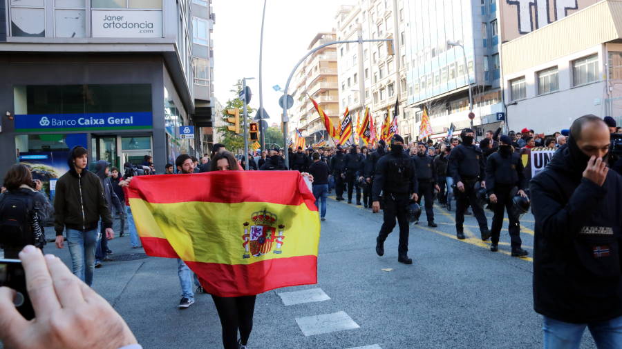 Una participant de la contramanifestaci&oacute; unionista exhibeix una bandera espanyola al pas de la manifestaci&oacute; antifeixista per Via Augusta. FOTO: ACN