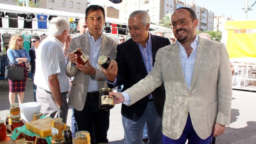 El cap de llista del PP per la demarcació de Tarragona, Alejandro Fernández (dreta), al costat de Javier Arenas i Fernando Martínez Maíllo, observant uns pots de mel al mercat setmanal de Sant Pere i Sant Pau en una passejada e
