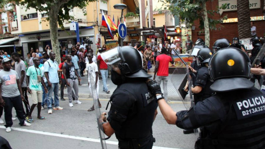 Efectius dels Mossos d'Esquadra, davant els manifestants senegalesos, al carrer Barcelona de Salou. FOTO: ACN
