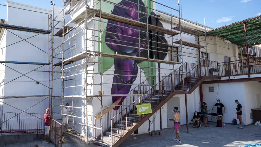 El mural, feminista i antiracista, presidirà ara els balls en aquesta pista. FOTO: JOAN REVILLASALBERT BONET, AHIR A LA TARDA, DAVANT DE LA SEVA OBRA. FOTO: JOAN REVILLAS