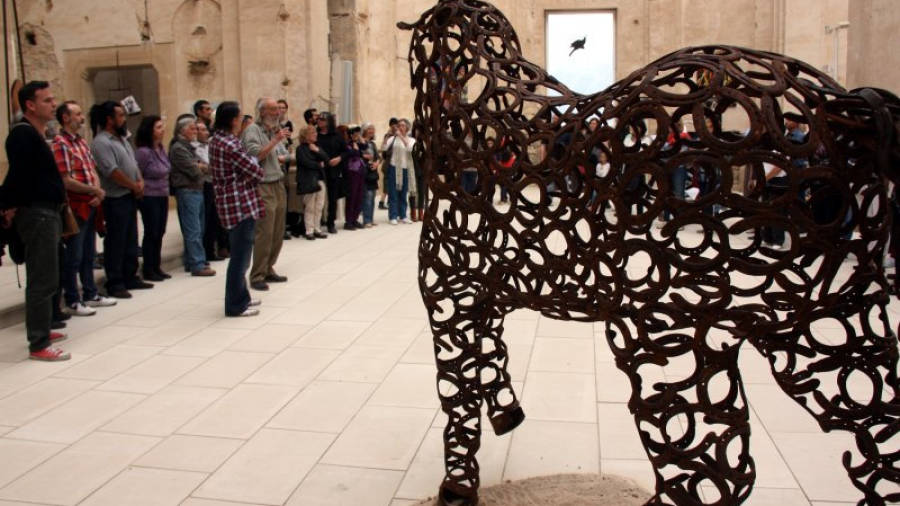 Un imponent cavall d'acer al costat de la foto de família de molts dels artistes que han participat a la Biennal d'Art de Corbera d'Ebre. Foto: ACN