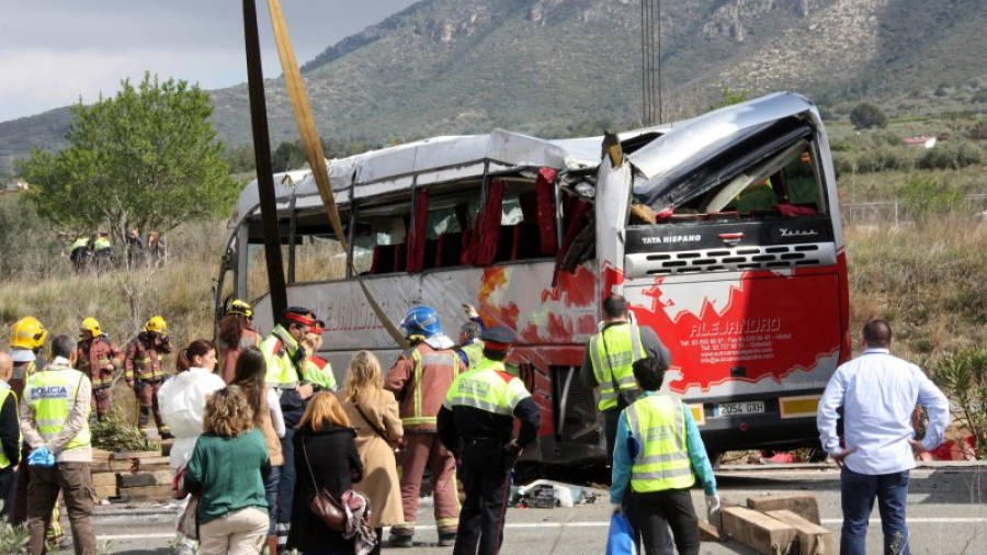 Efectius dels Bombers i Mossos observant l'autobús accidentat un cop la grua l'ha aixecat. Foto: ACN