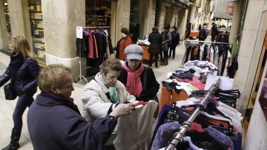 Tres mujeres miran piezas de ropa en una tienda de la calle Galera, ayer por la mañana. Foto: Alba Mariné
