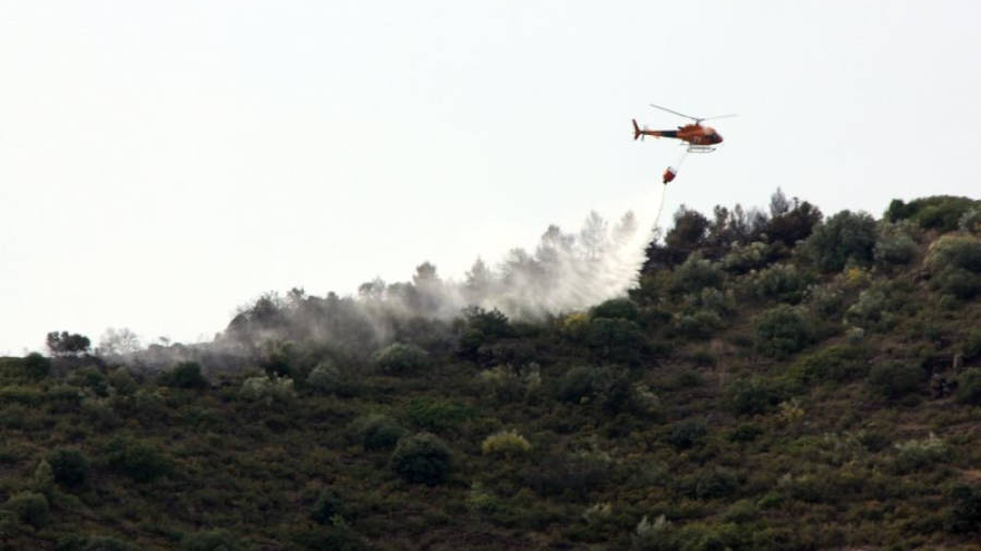 Un helicòpter descarregant aigua al perímetre de l'incendi de Gratallops. Foto: ACN
