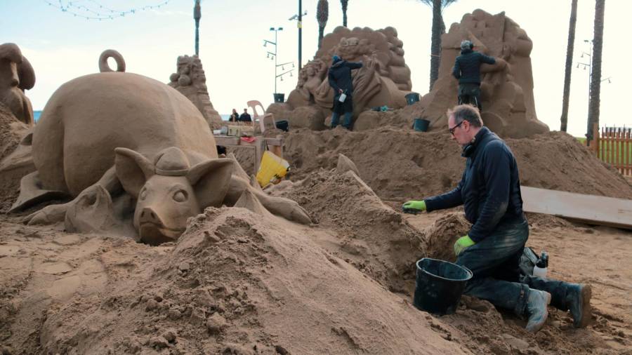 L’artista danès Bruno MacDonald treballa en una de les escenes del pessebre de sorra de la Pineda. Foto: ACN