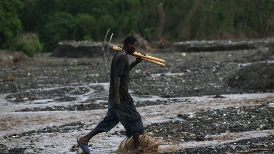 Un hombre cruza el río Digue tras el paso del huracán Matthew. Haití vive tres días de luto por los cientos de víctimas causadas por el ciclón. EFE