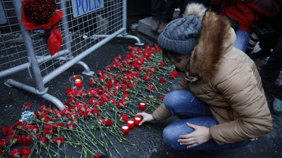 La gente pone flores y velas en una valla policial en frente de la discoteca Reina después de un ataque de armas. Foto: EFE