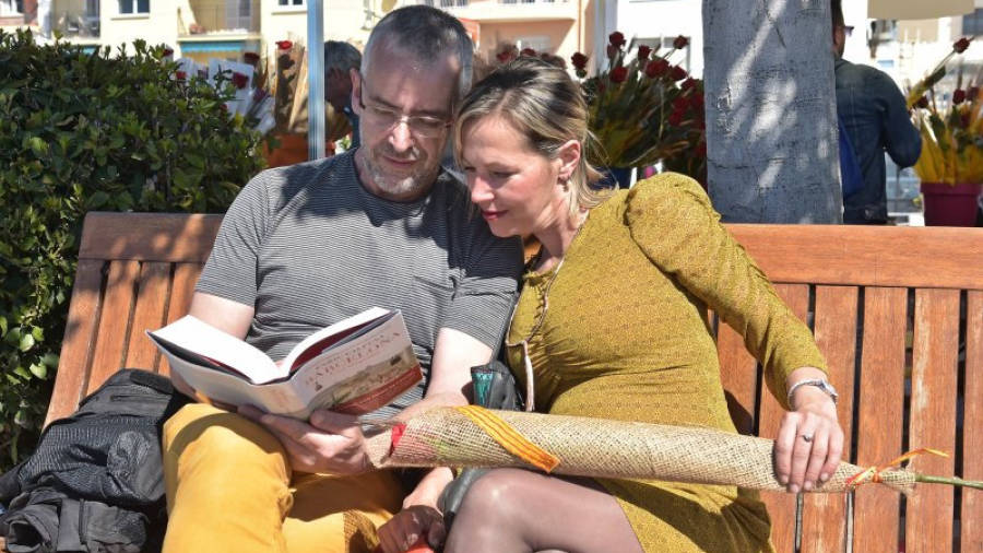 Imatge d'una parella celebrant el Sant Jordi a Cambrils amb un llibre i una rosa. Foto: Alfredo González