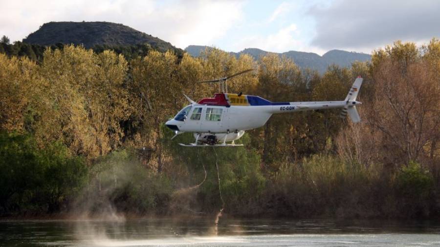L'helicòpter buida la càrrega d'insecticida biològic BTI al riu Ebre, a l'alçada de l'assut de Xerta. Foto: ACN