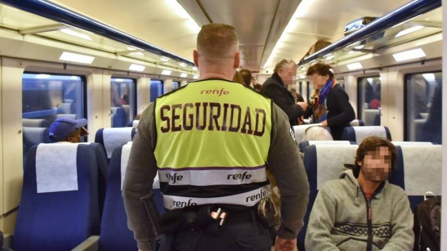 Un vigilante de seguridad patrullando por el interior de un vagón de Renfe. Foto: Alfredo González