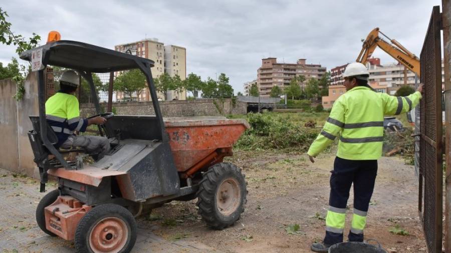 Dos operarios, en pleno trabajo de limpieza de vegetación y retirada de suciedad en Mas Mainer. FOTO: ALFREDO GONZÁLEZ