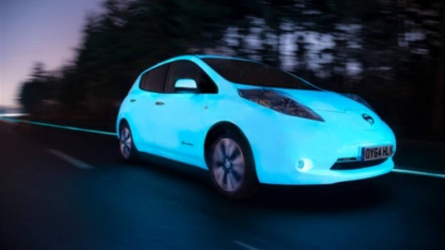 Leaf, primer coche 100% eléctrico que brilla en la oscuridad que circula por una autopista brillante.