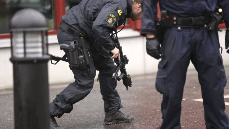 Agentes de policía suecos inspeccionan la zona después de que un hombre enmascarado atacara a varias personas con una espada antes de ser disparado por la policía en una escuela en Trollhättan (Suecia). Foto: EFE