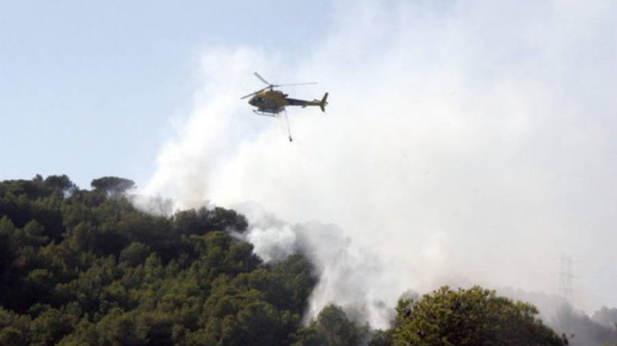 Un helicòpter descarrega aigua sobre l'incendi de Calafell. Foto:Acn