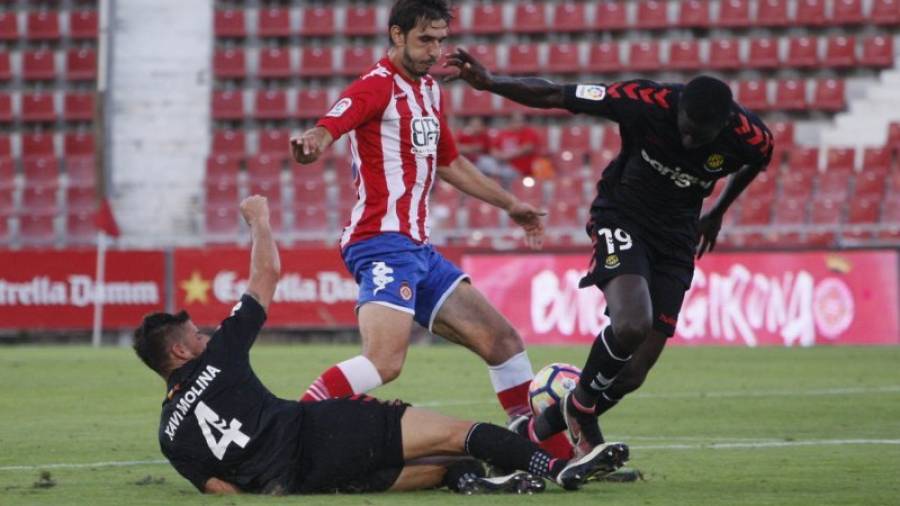 Xavi Molina y Zahibo tratan de arrebatarle el esférico a un jugador del Girona. Foto: Marc Martí/Diari de Girona