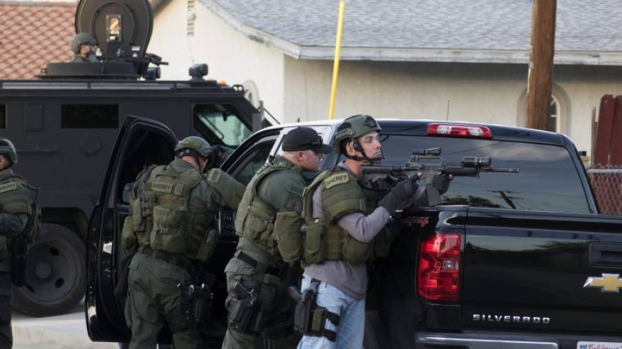 Oficiales de la policía buscan a los sospechosos cerca a la escena de un tiroteo hoy, miércoles 2 de diciembre de 2015, en el Centro Regional Inland en San Bernardino (California, USA). EFE/EUGENE GARCIA