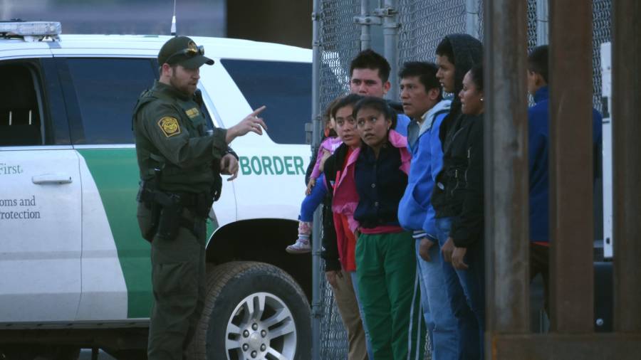 Un agente fronterizo de EEUU habla a un grupode migrantes detenidos en Río Bravo. FOTO: EFE