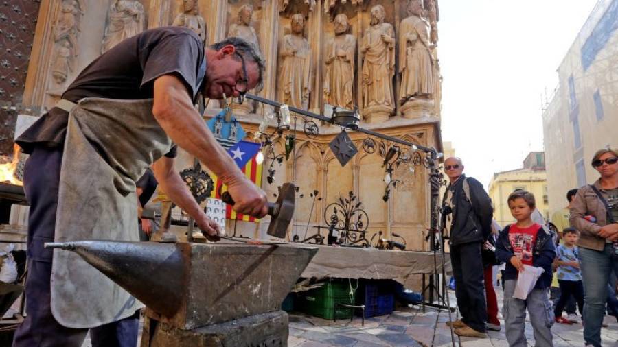 Los hermanos Mercadé muestran el oficio de forjador a las puertas de la Catedral de Tarragona. Foto: Lluís Milián