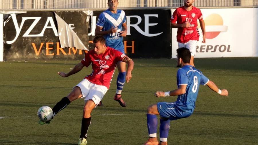 Vadillo despeja el esférico ante la presencia de un futbolista del Badalona en el partido de ida disputado en la Pobla. Foto: lluís milián