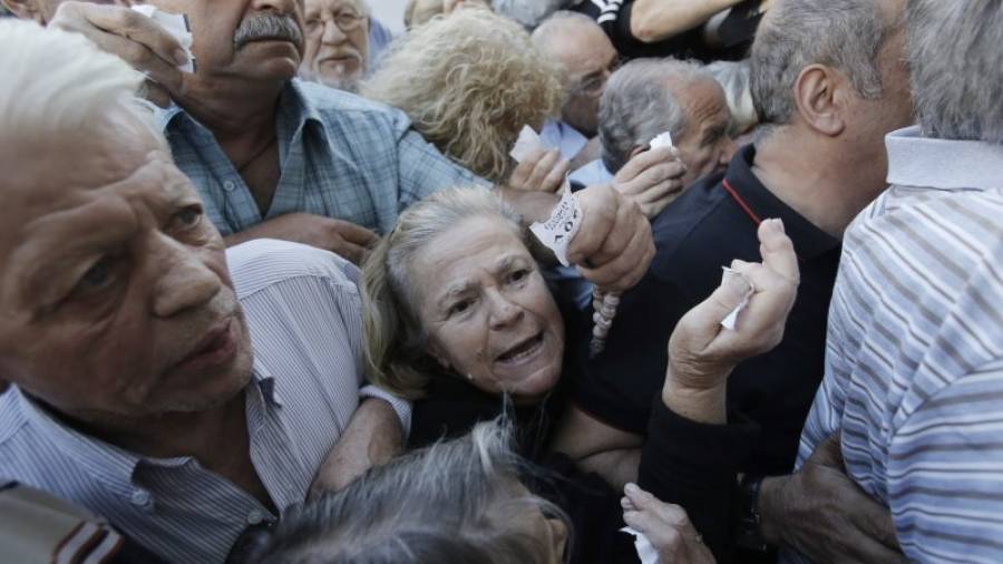 Una multitud de pensionistas se agolpa en una sucursal para poder retirar parte de sus pensiones, ayer en Atenas. Foto: yannis kolesidis/EFE