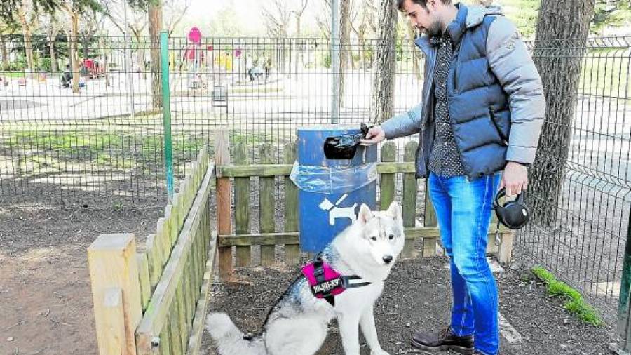 El propietario de un perro deposita una bolsa con el excremento de su mascota en una papelera especial en el Parc de Sant Jordi. FOTO: ALBA MARINÉ