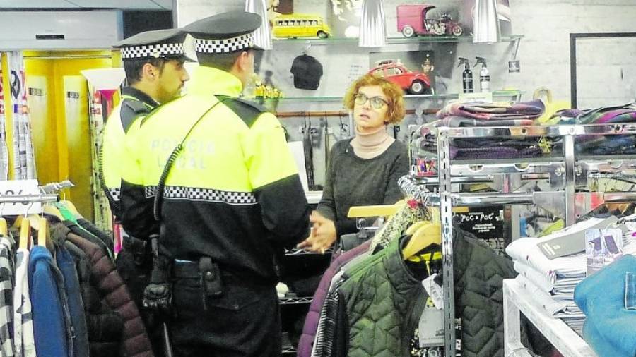 Els agents de la Policia Local parlant amb una de les comerciants que hi ha al carrer Barcelona.