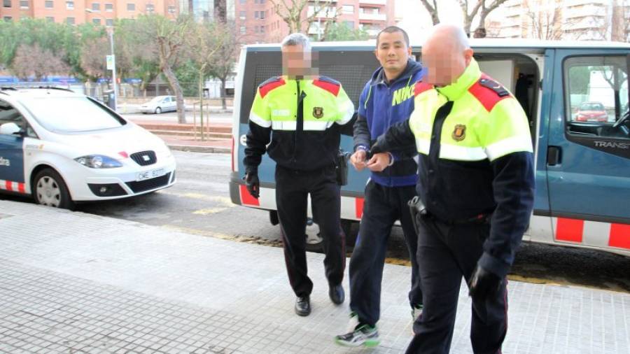 Dos agentes durante el traslado de un detenido al Juzgado de Guardia de Tarragona. Foto: Lluís Milián