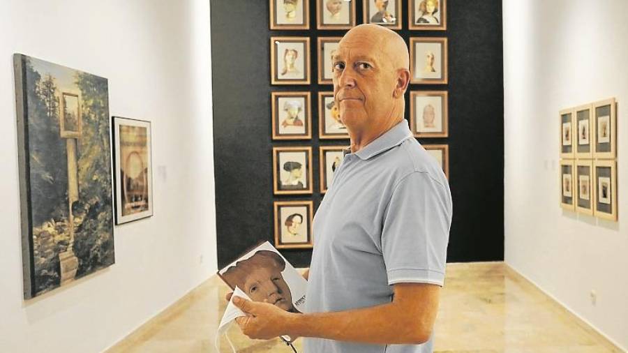 Catálogo en mano, Quim Martín, pareja de Toni Torrell, con los collages de retratos al fondo. Foto: Pere Ferré