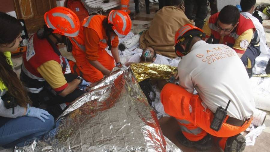 Personal sanitario atienden a uno de los heridos en el incendio de una vivienda situada en una planta 14 de un edificio del barrio de la Albufereta, en la ciudad de Alicante, donde han sido rescatadas más de diez personas. EFE/MORELL