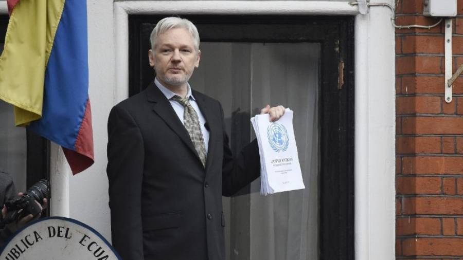 Julian Assange muestra la resolución desde el balcón de la embaja de Ecudor en Londres. Foto: EFE