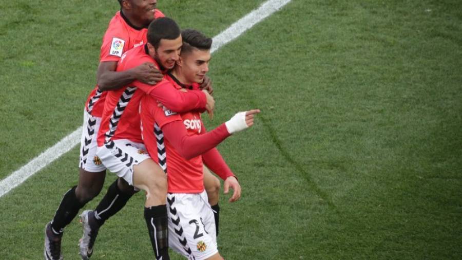 Aburjania y Jean Luc saltan sobre Naranjo, que celebra con la afición su octavo gol en la Liga Adelante. Foto: Lluís Milián