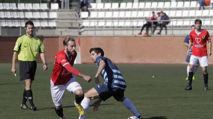 El jugador grana Sergi Moreno se va de un defensa en un duelo de esta temporada en la Pobla. Foto: Pere Ferré